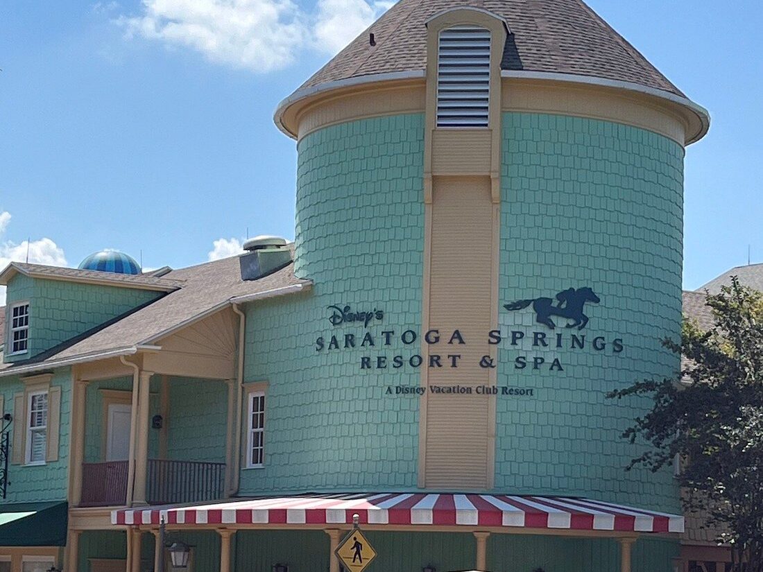 Entrance building at Disney’s Saratoga Springs Resort and Spa with green exterior and signage
